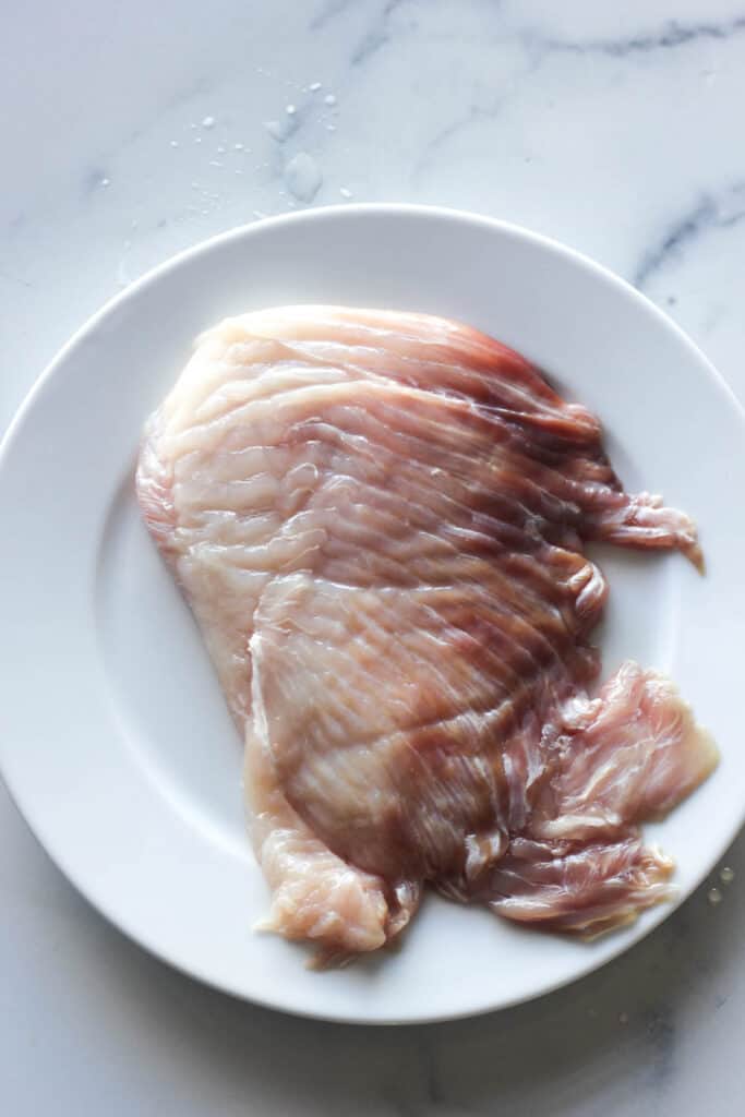 raw scate wing fillet on the white plate